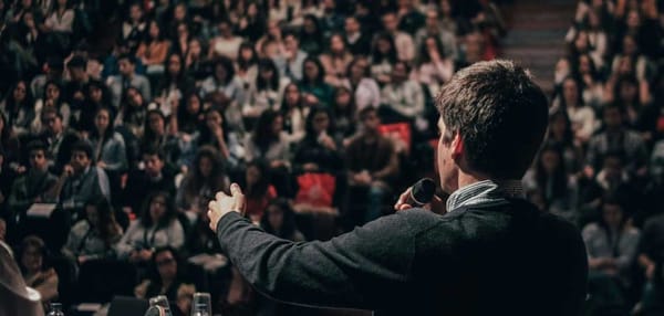 Politician speaking to a full auditorium - Miguel Henriques, Unsplash 